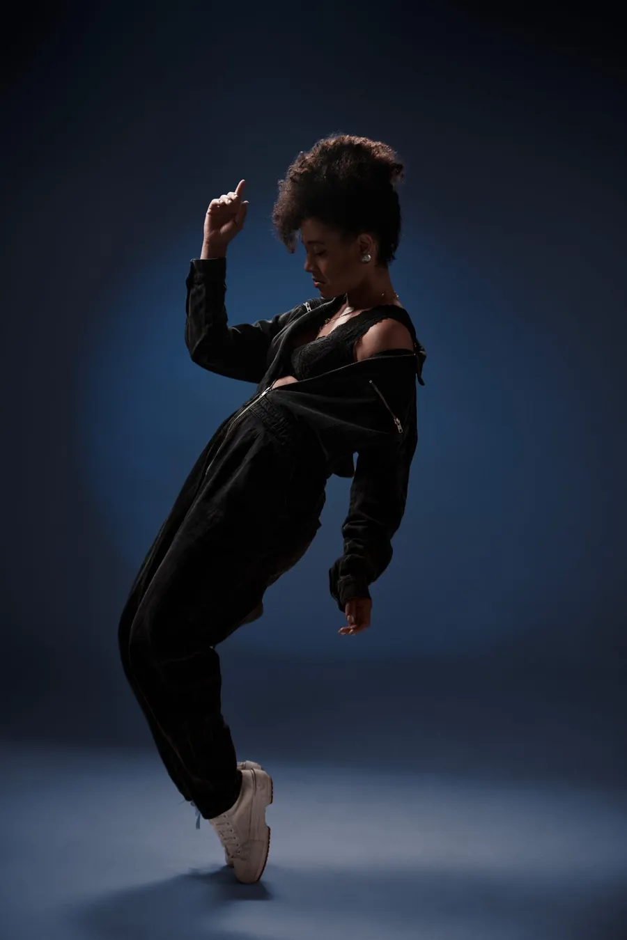 Arlene Gould dancing in a dark studio, lit in deep blue